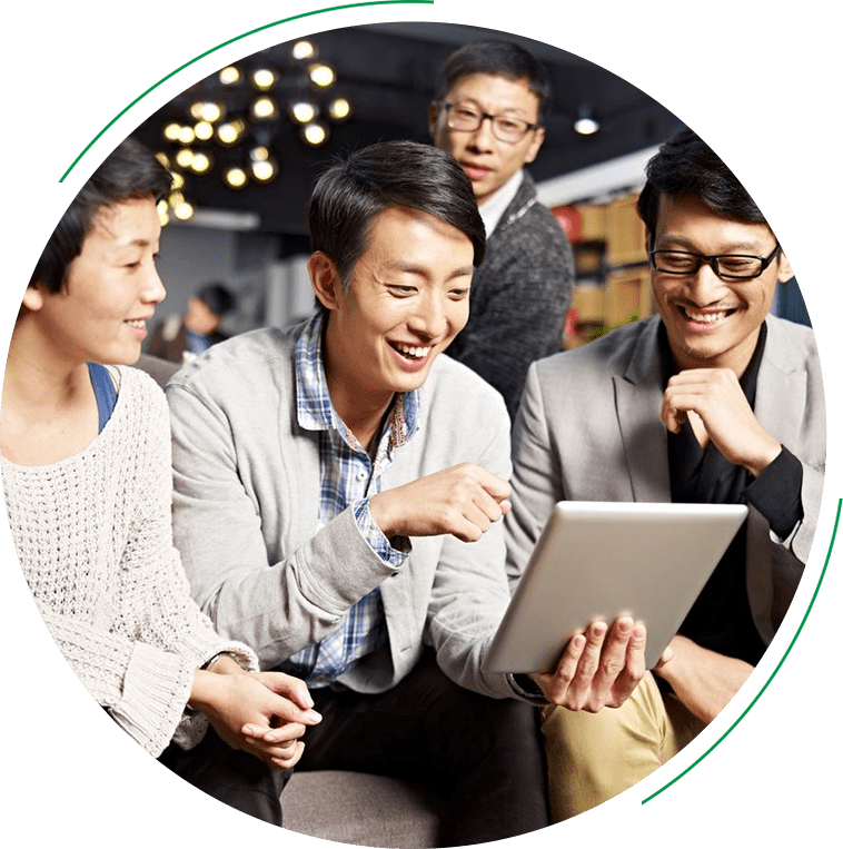 A group of people sitting around looking at a tablet.